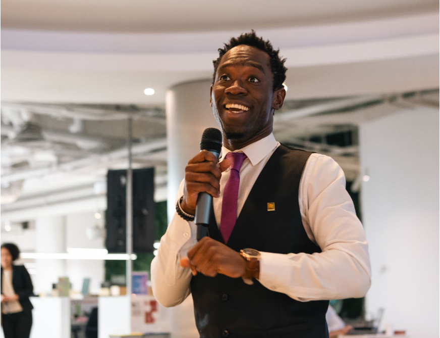 Steven Dossou speaking with a microphone